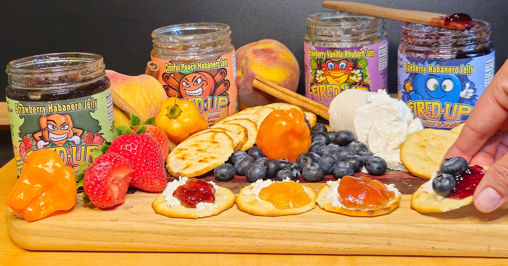 Assorted jars of fruit preserves on a charcuterie board with fruits and crackers.